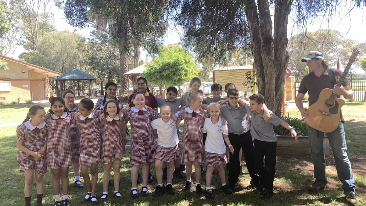 Students from Beelbangera Public School rehearsing their new school song with musician Josh Arnold. Picture by Cai Holroyd