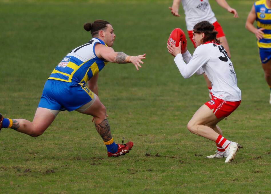 Griffith's Jay Summers looks to evade a tackle from MCUE's Wilson Morshead during the Swans win against the Goannas. Picture by Les Smith