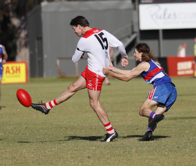 Griffith's Henry Delves gets a kick while under pressure from Turvey Park's Harry Woods during their clash at Maher Oval. Picture by Les Smith
