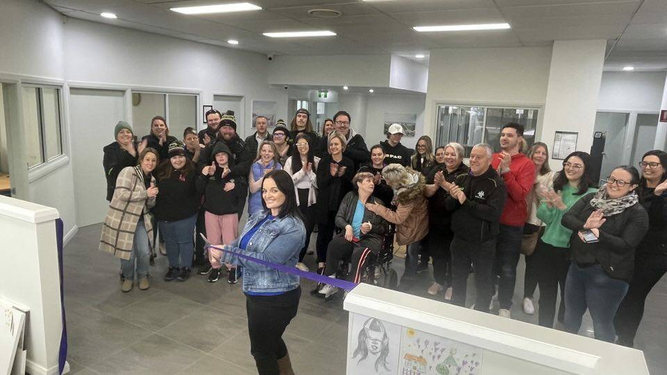A crowd applauds the officially opening of the new My Plan Connect hub on Friday, with staffer Marlena Trembath cutting the ribbon. Picture by Allan Wilson